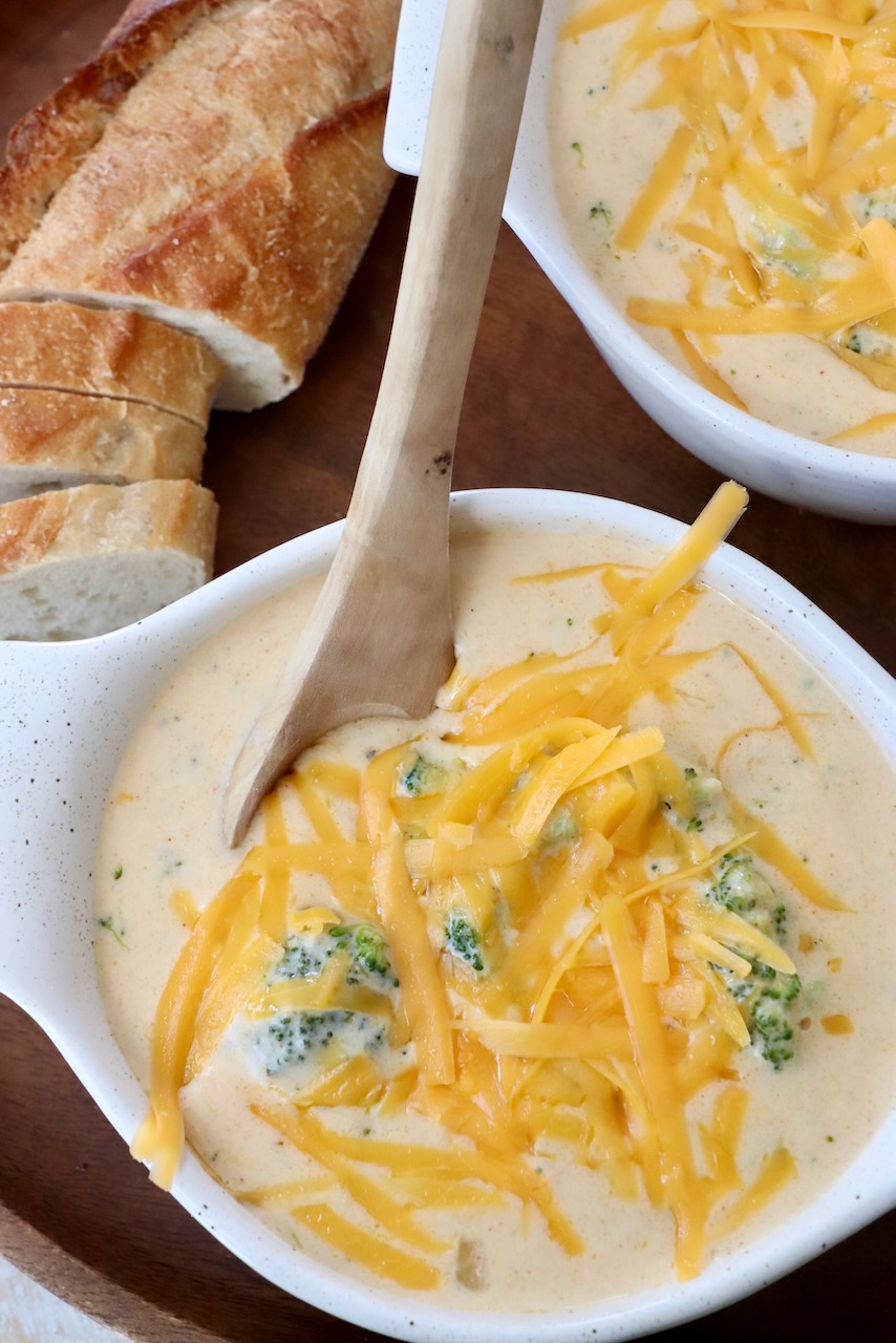 broccoli cheddar soup in bowl with wooden spoon