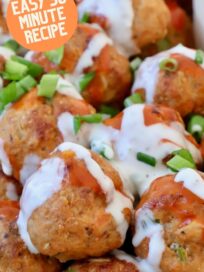 buffalo chicken meatballs stacked up on plate drizzled with blue cheese dressing