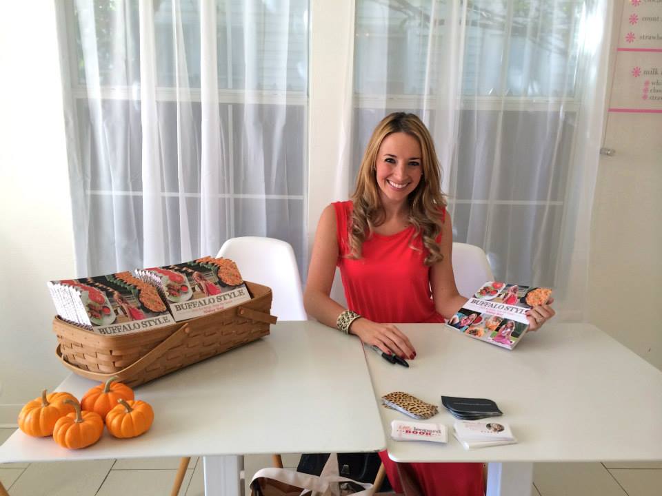 whitney bond sitting at table with cookbooks