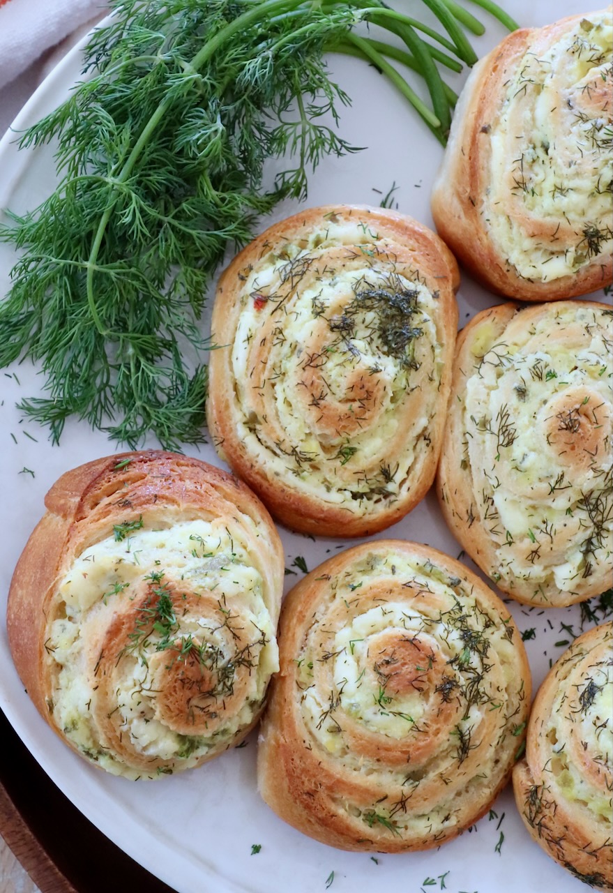 baked creamy pickle rolls on plate with fresh dill
