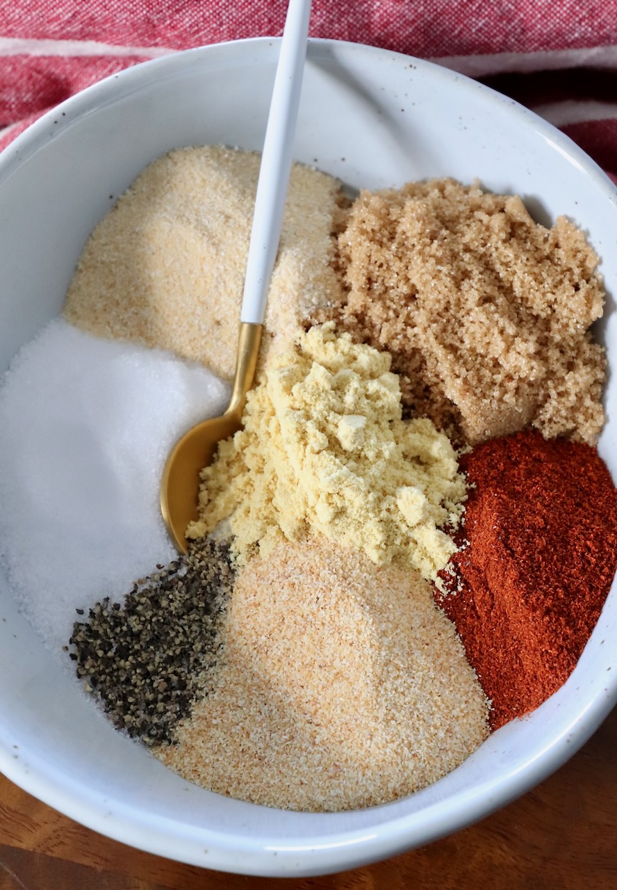 spices and brown sugar separated in bowl with a spoon