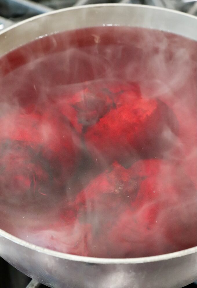 beets boiling in water in a pot on the stove