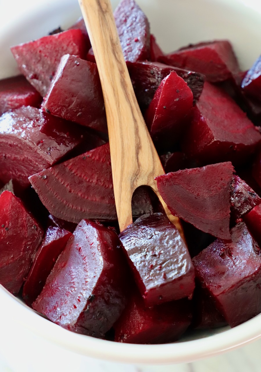 cooked diced beets in bowl with wooden fork