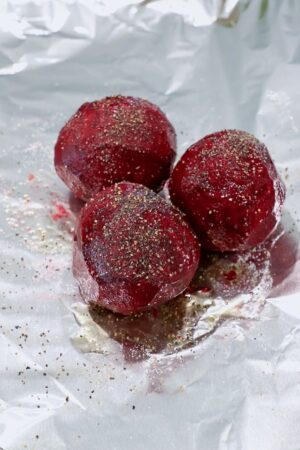 seasoned raw peeled beets on a piece of foil