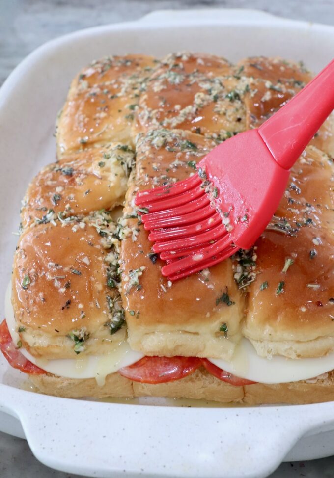 Italian sub sliders in casserole dish brushed with herb butter