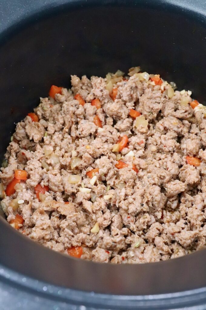 cooked Italian sausage in pot with diced vegetables