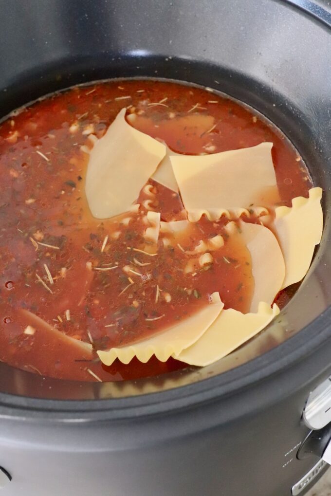broken lasagna noodles in tomato sauce in slow cooker