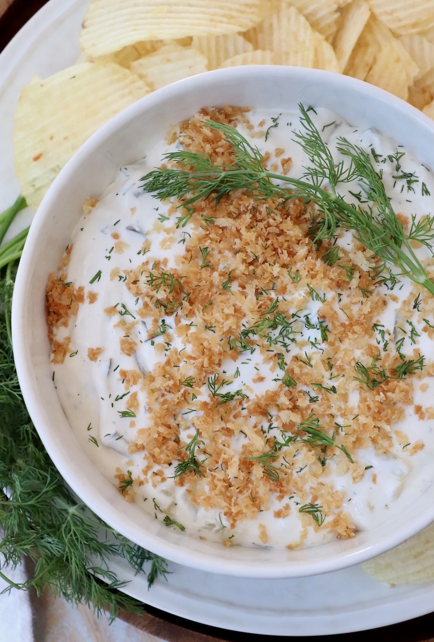 pickle dip in bowl topped with fresh dill and toasted breadcrumbs