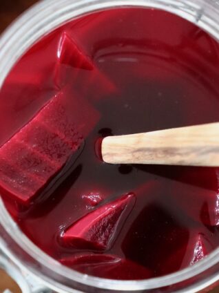 pickled beets in jar with wooden spoon