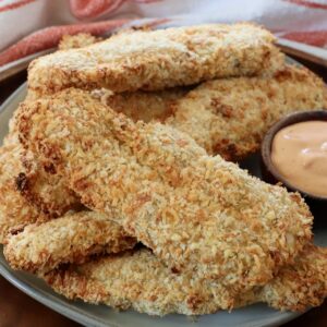 cooked, breaded chicken strips on a plate