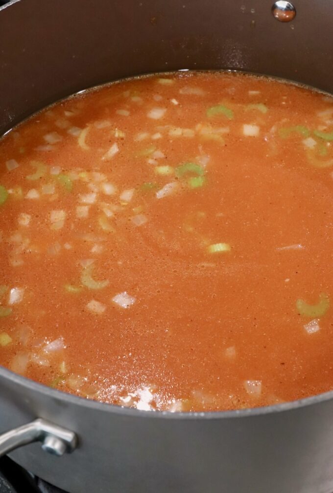 seasoned chicken broth with diced veggies in pot