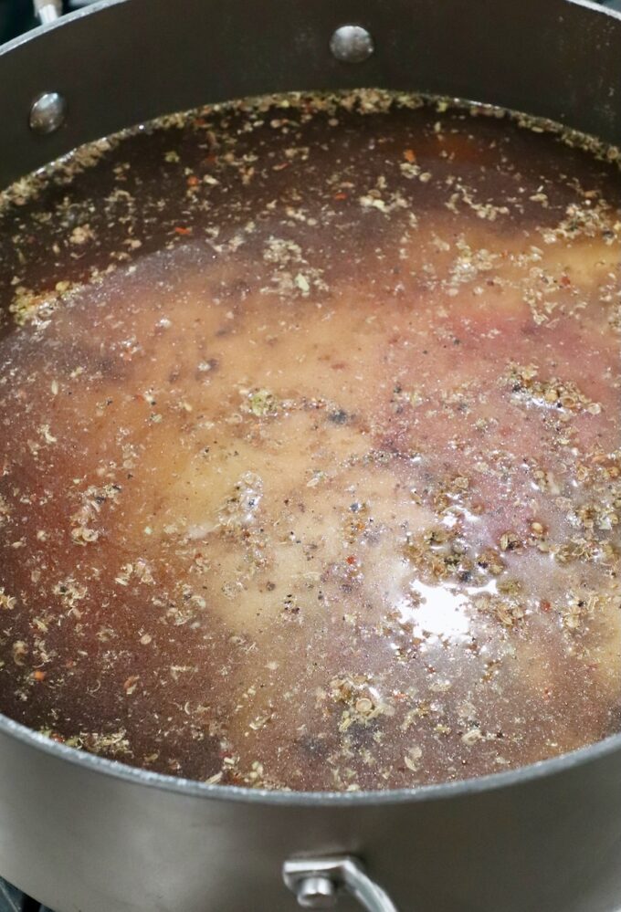 beef brisket covered in beef broth in dutch oven