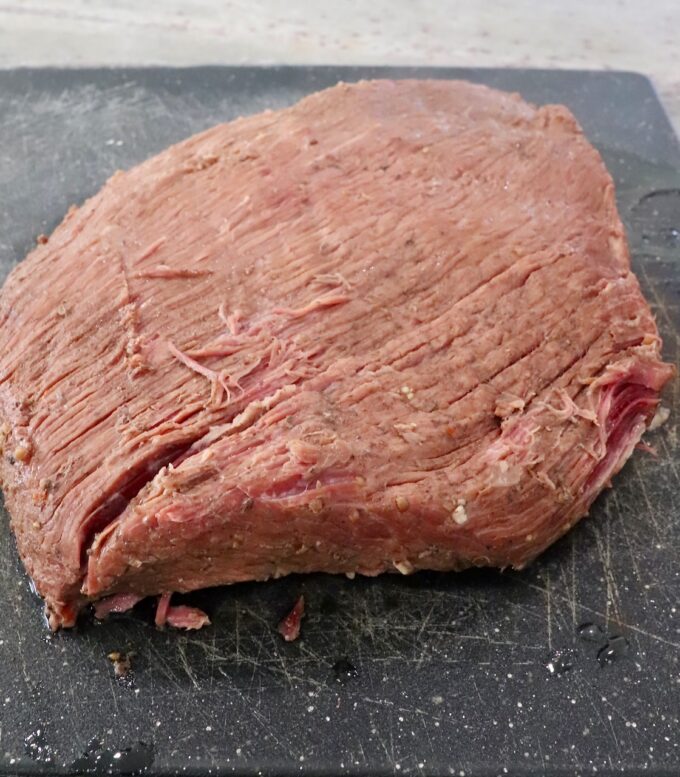 cooked brisket on cutting board