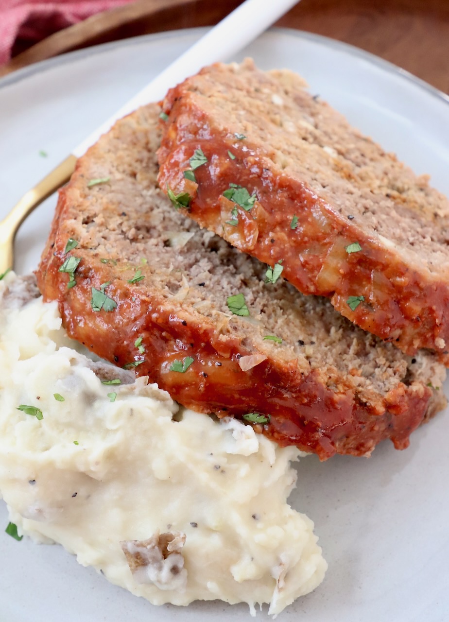 two slices of meatloaf on a plate with mashed potatoes