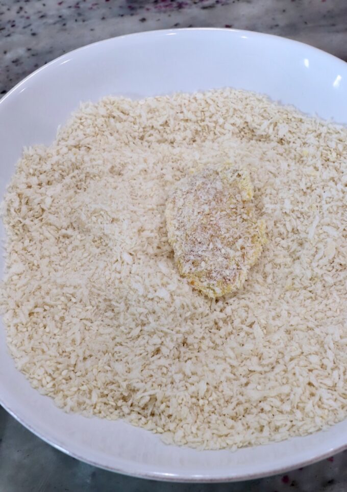 piece of chicken coated in breadcrumbs in a bowl