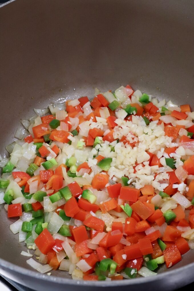cooked diced onion, bell pepper and jalapeno in a pan on the stove