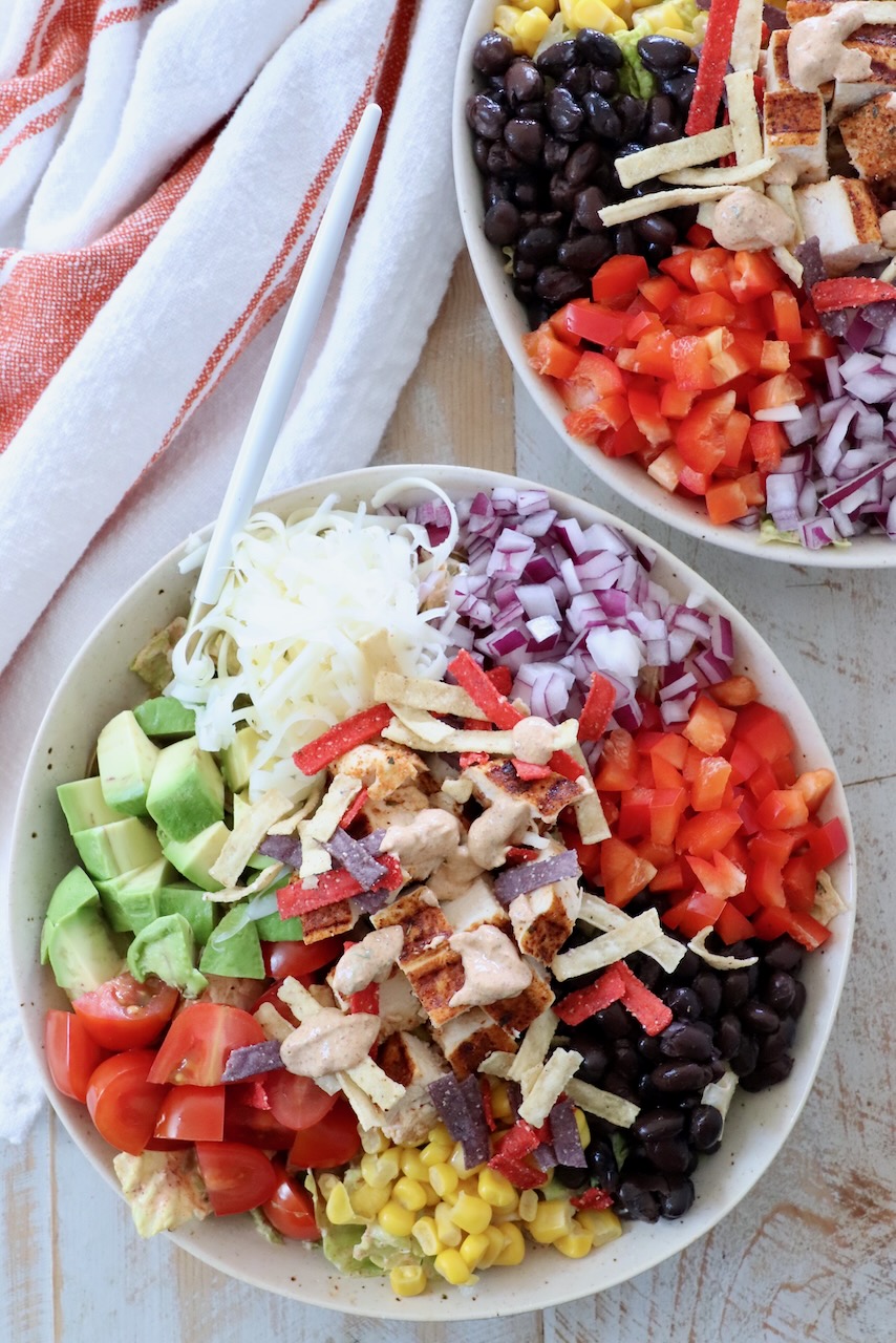 southwest salad in bowl topped with diced grilled chicken