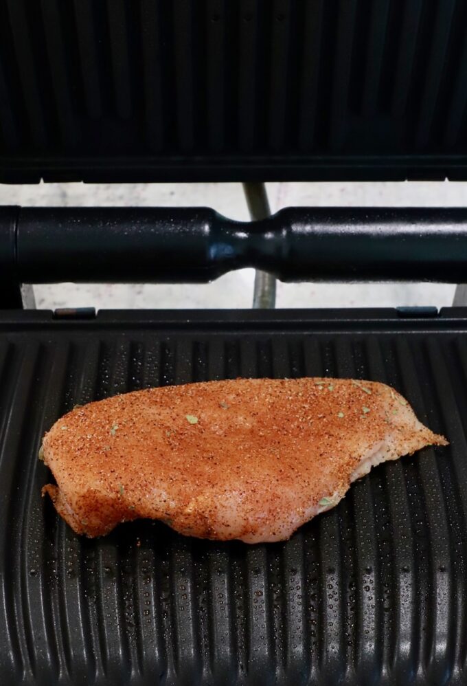 uncooked seasoned chicken breast in grill
