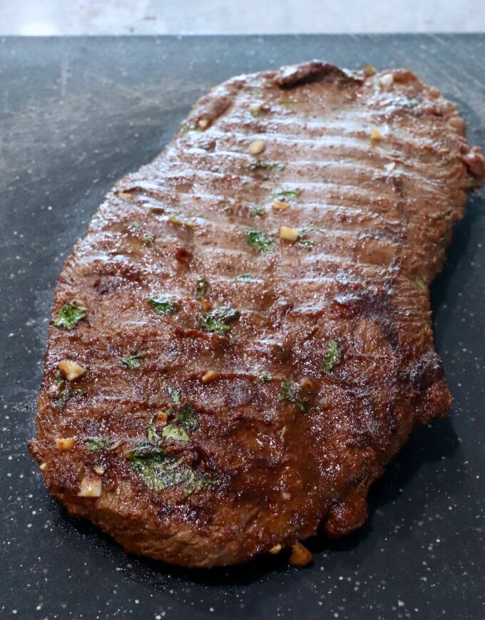 grilled flat iron steak on cutting board