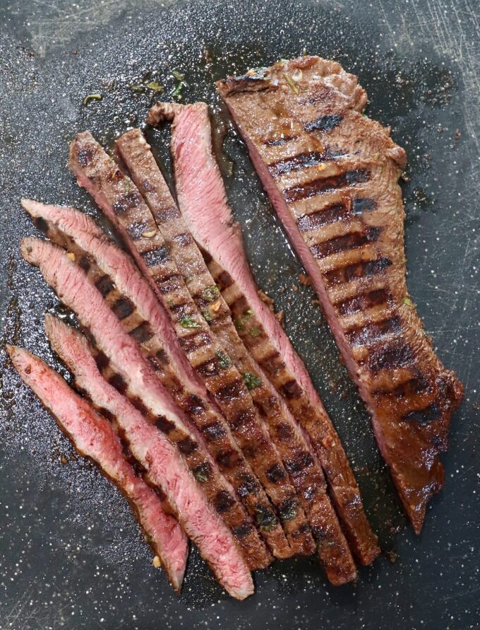 sliced grilled steak on cutting board