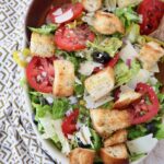 salad in bowl with croutons and sliced tomatoes