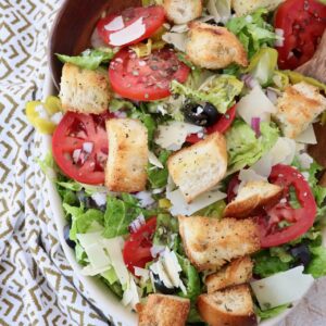 salad in bowl with croutons and sliced tomatoes