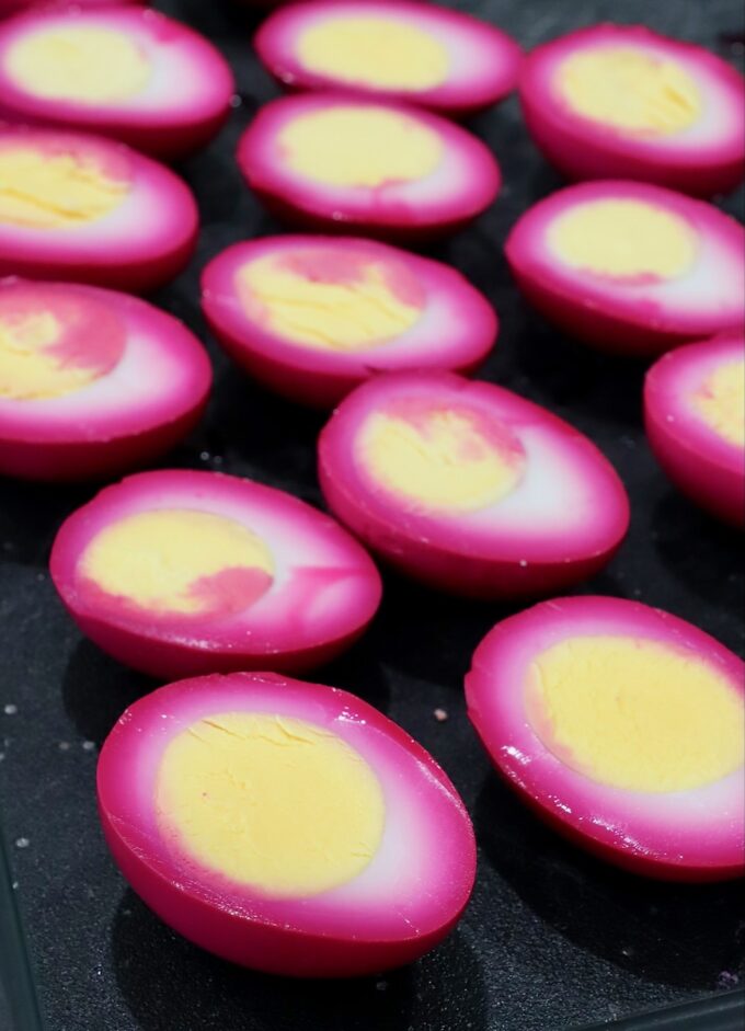 beet-pickled hard boiled eggs sliced in half on cutting board