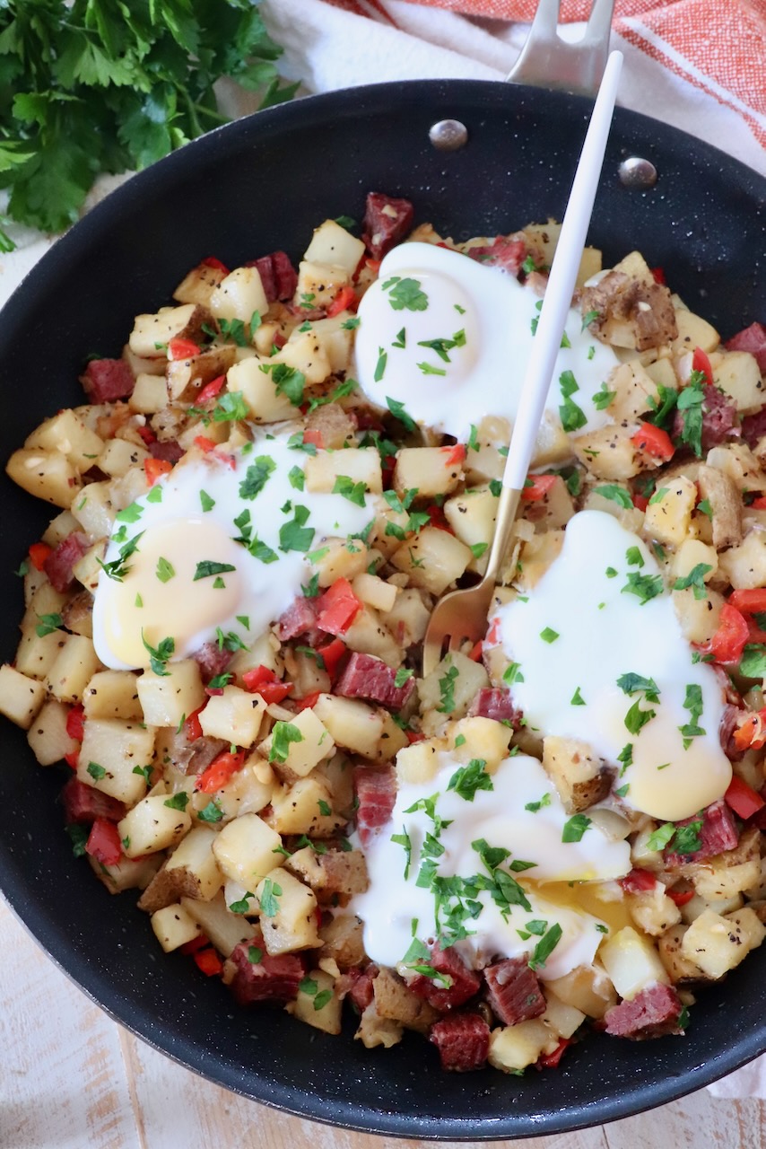 corned beef hash in skillet with fork