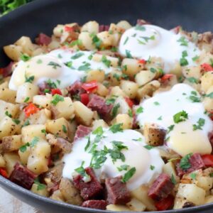 corned beef hash topped with eggs in skillet