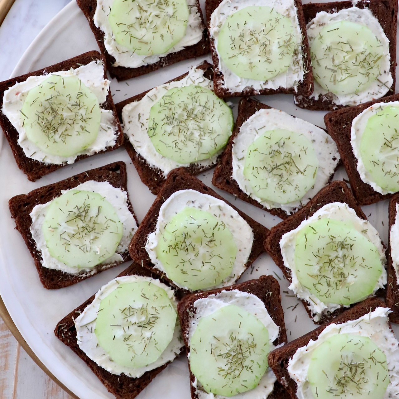 open-faced cucumber tea sandwiches on plate