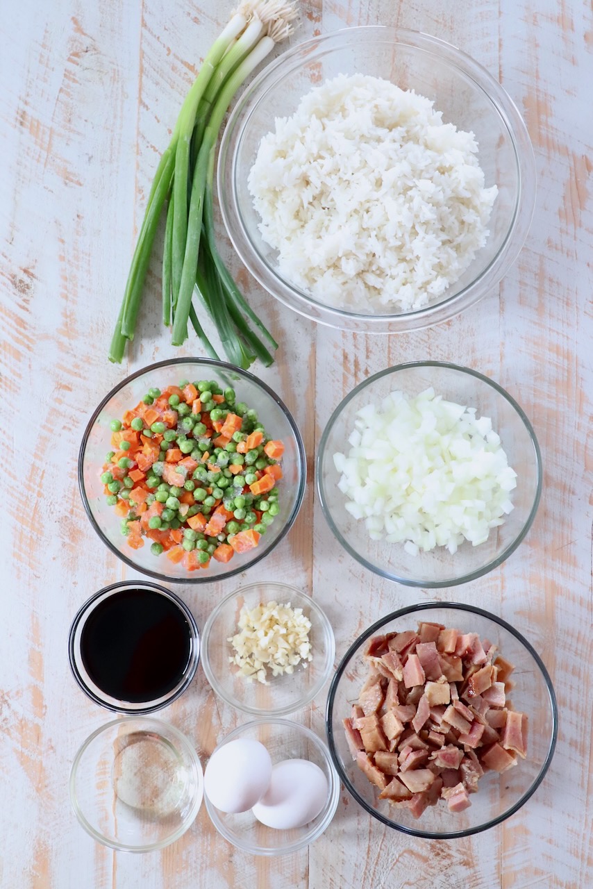 ingredients for ham fried rice on white wood board