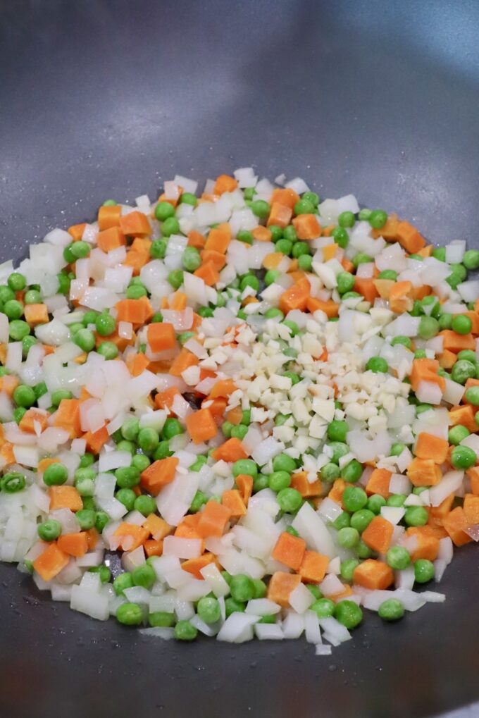 diced onions, carrots, peas and garlic in large skillet