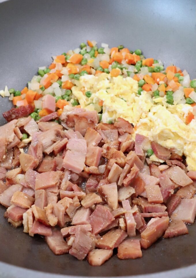 diced ham in skillet with scrambled eggs and veggies