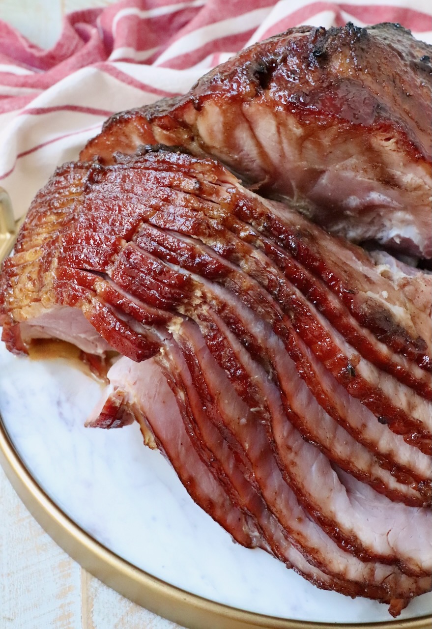 sliced honey baked ham on marble serving tray