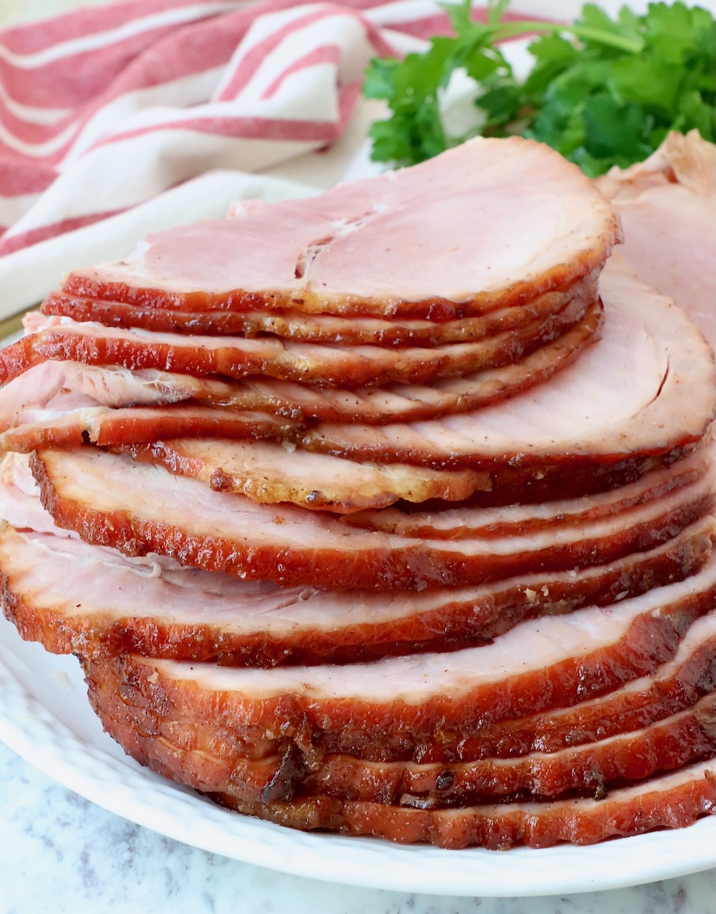 sliced ham stacked up on a plate