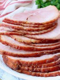 slices of ham stacked up on a plate
