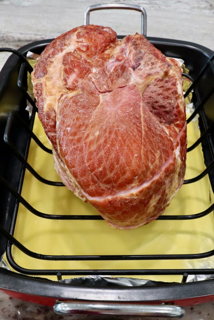 spiral ham in roasting pan with pineapple juice