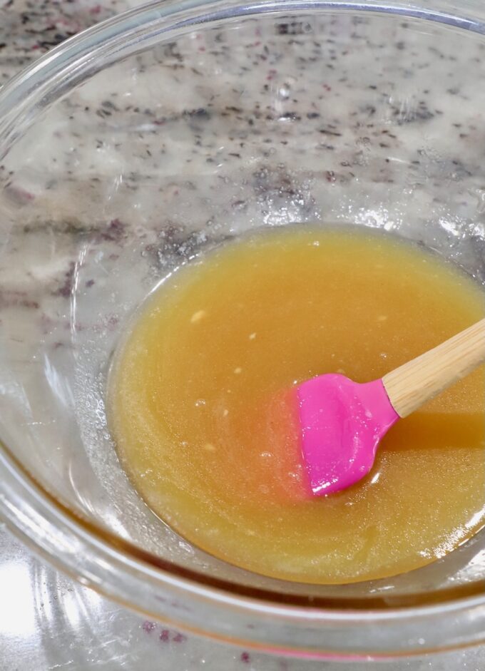 honey glaze in bowl with pink spatula