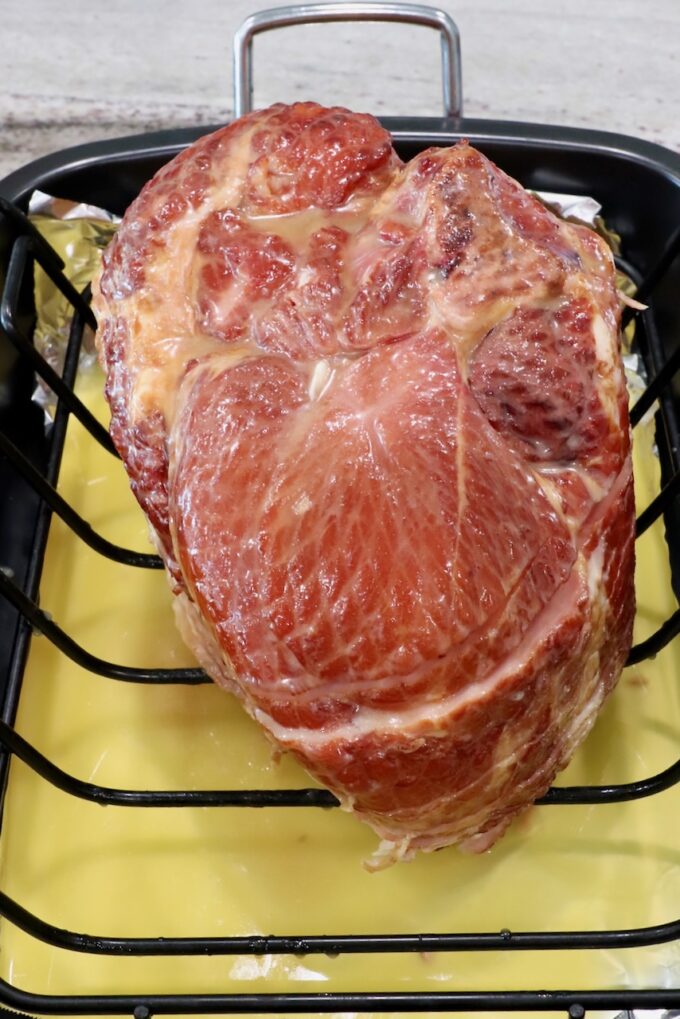 honey glazed ham in roasting pan with pineapple juice