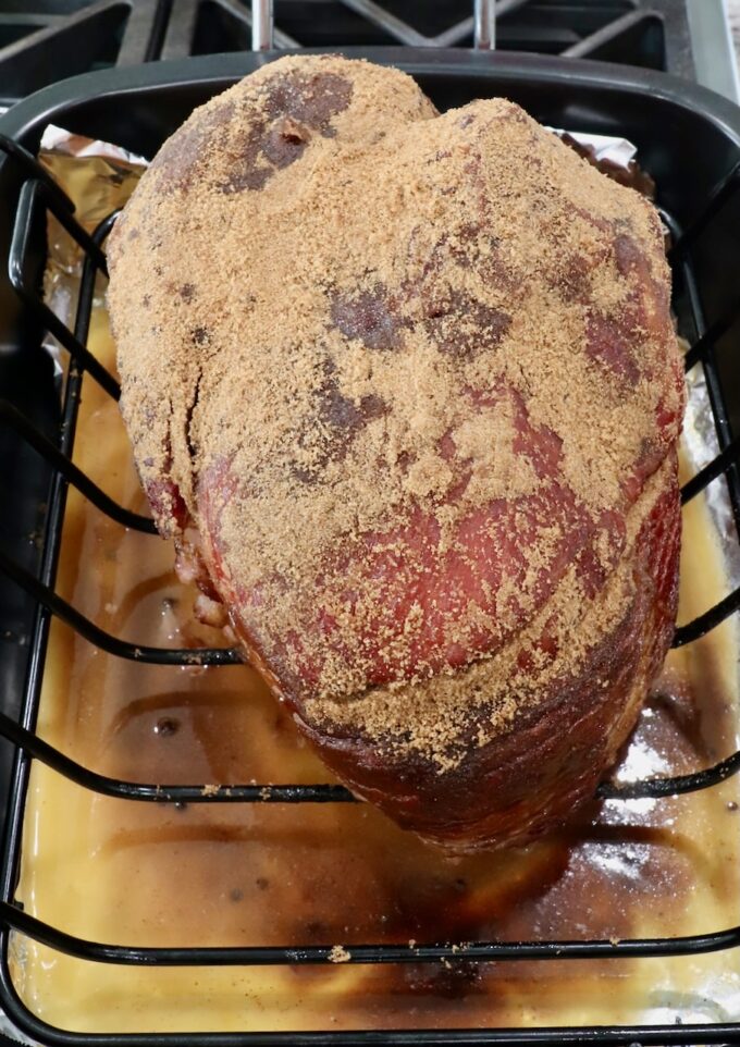 brown sugar covered spiral ham in roasting pan