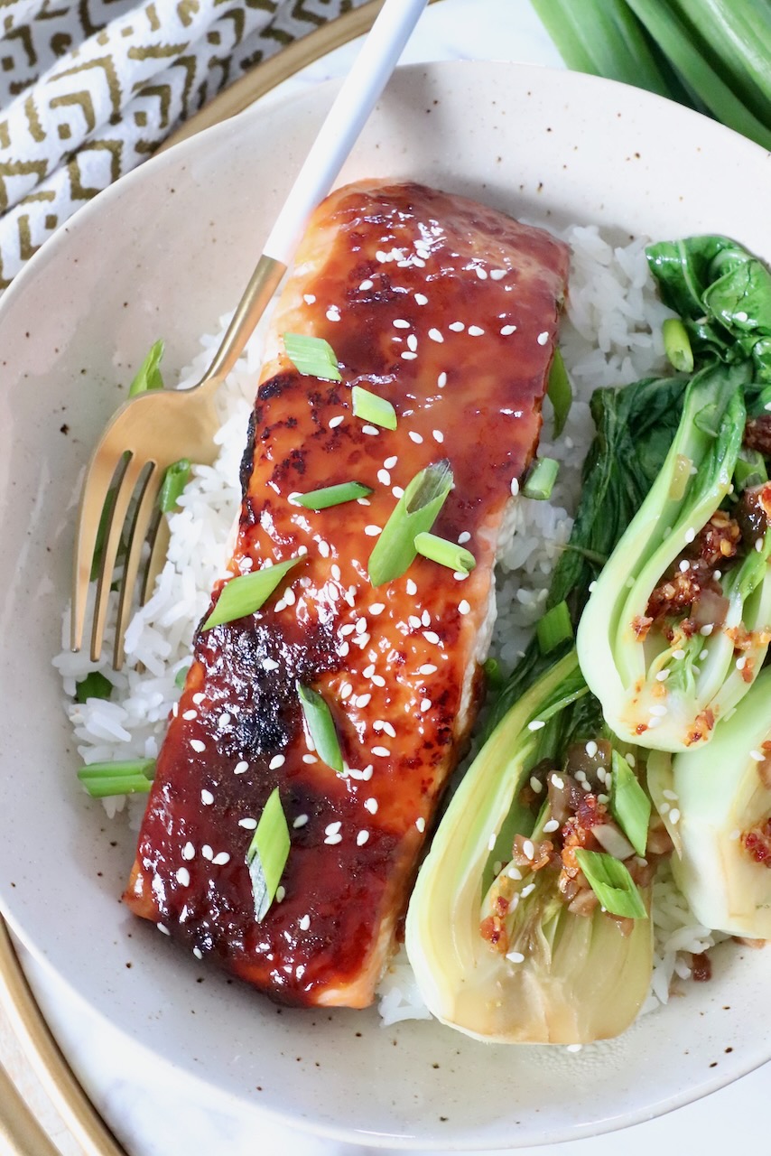 piece of cooked miso glazed salmon in bowl with cooked rice and baby bok choy