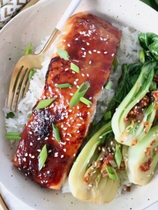 filet of cooked miso glazed salmon in bowl with fork and baby bok choy