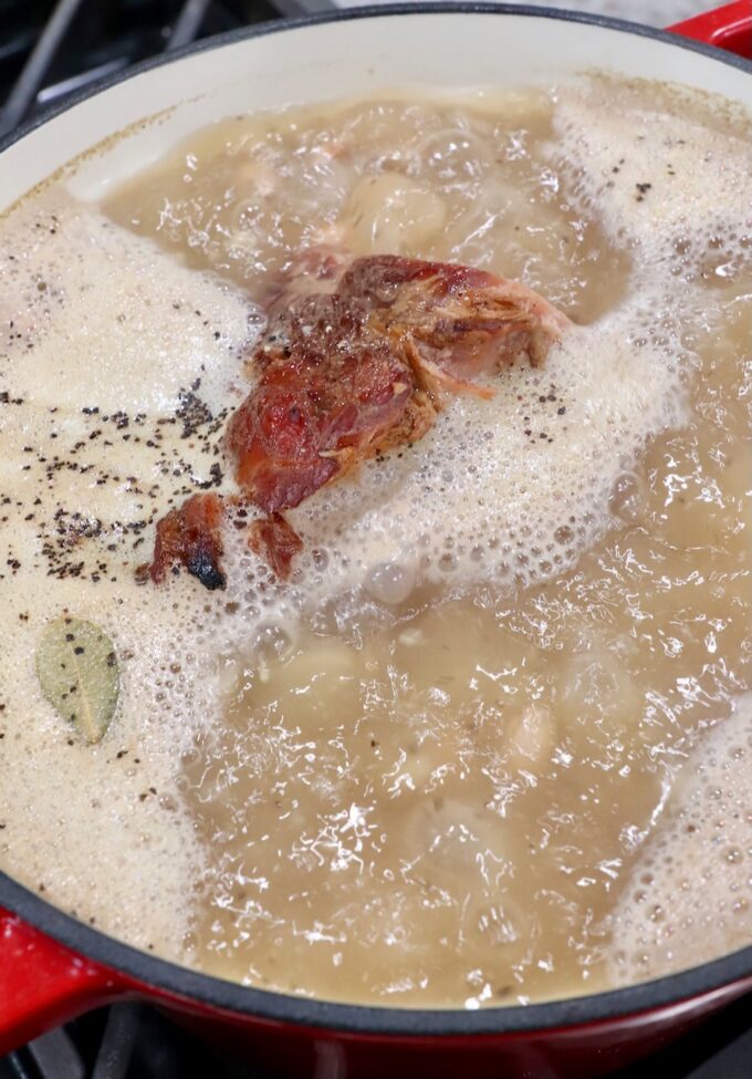ham bone simmering in liquid in pot