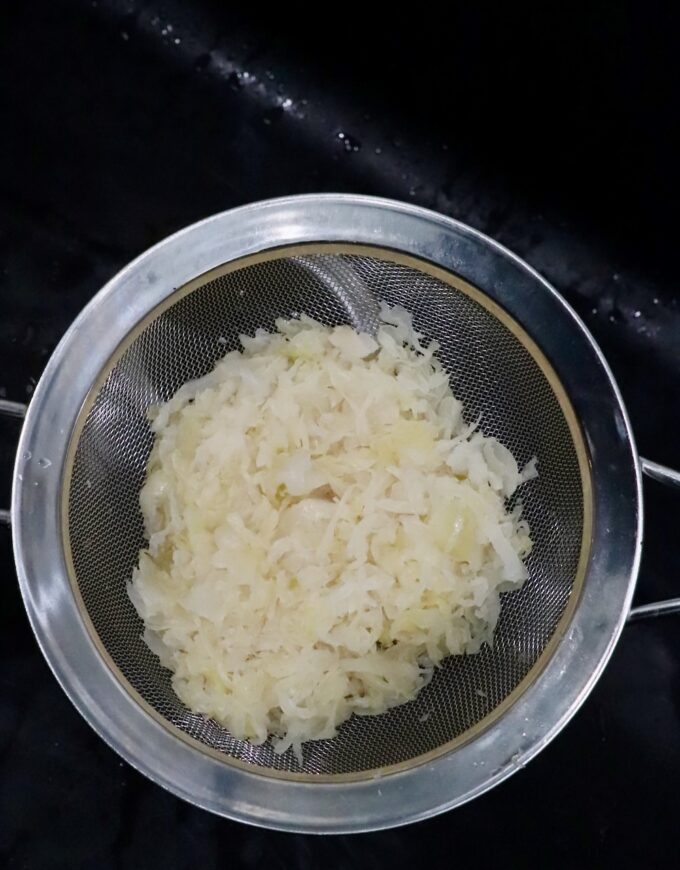sauerkraut in fine mesh strainer in sink