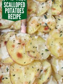 cooked scalloped potatoes in baking dish with serving spoon