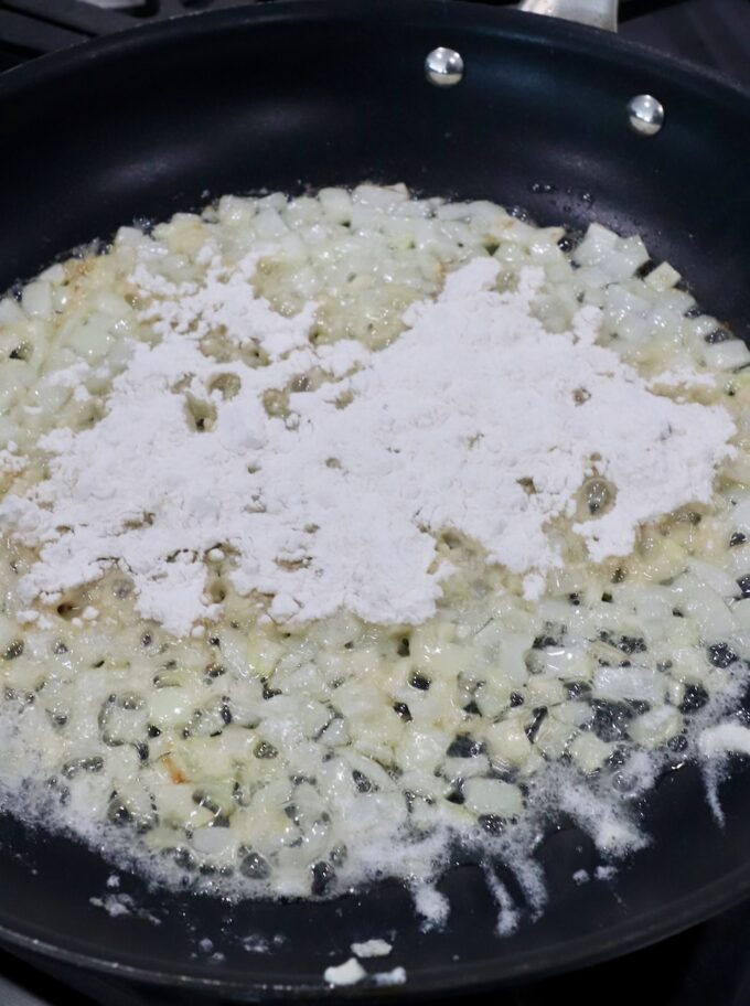 diced onions and minced garlic in skillet with melted butter topped with flour