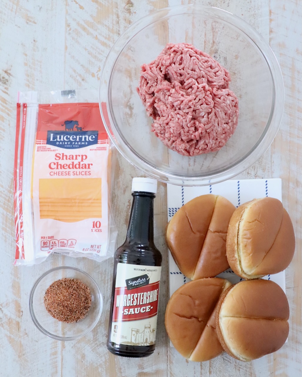 ingredients for air fryer cheeseburgers on white wood board