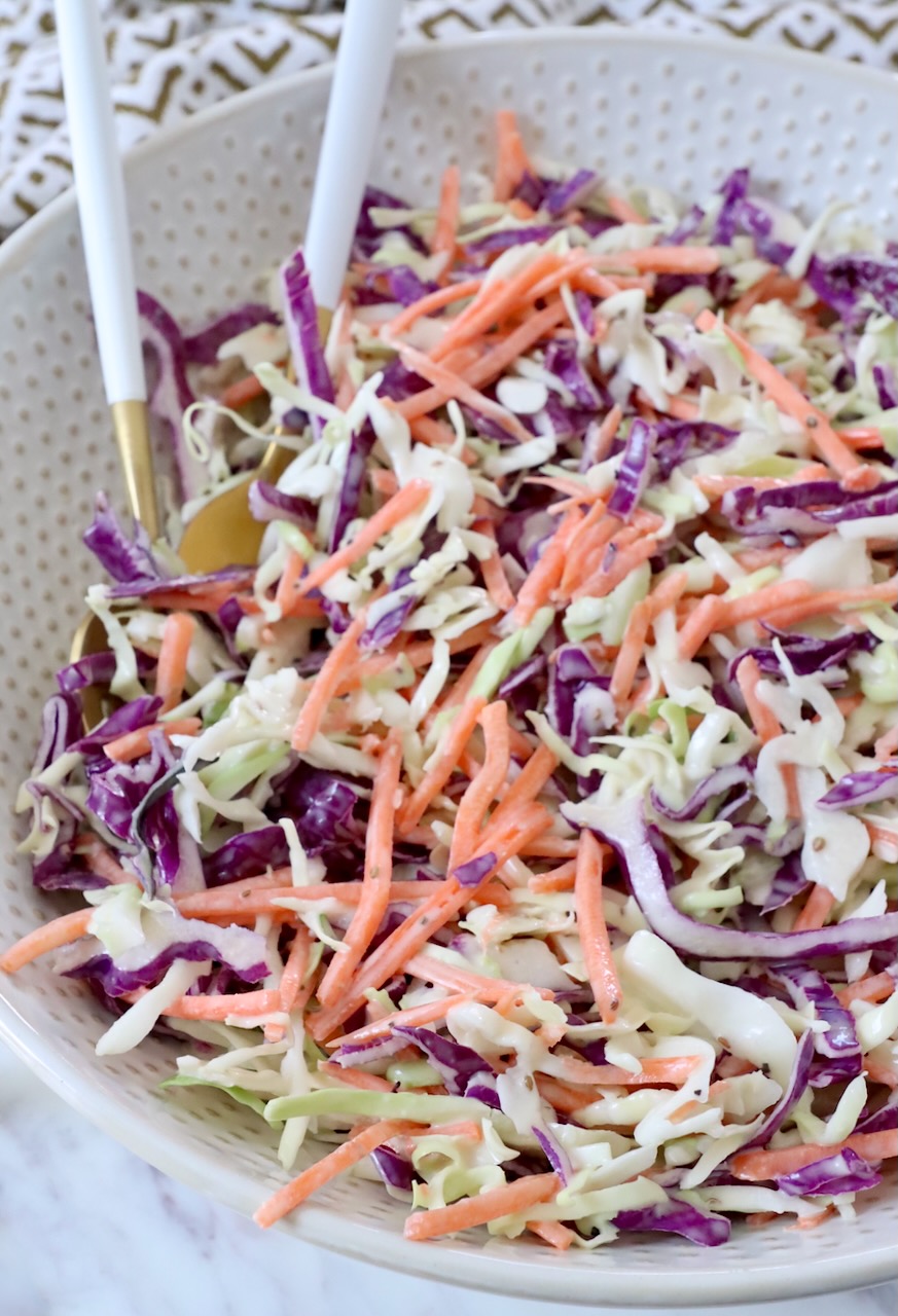 prepared coleslaw in bowl with spoons