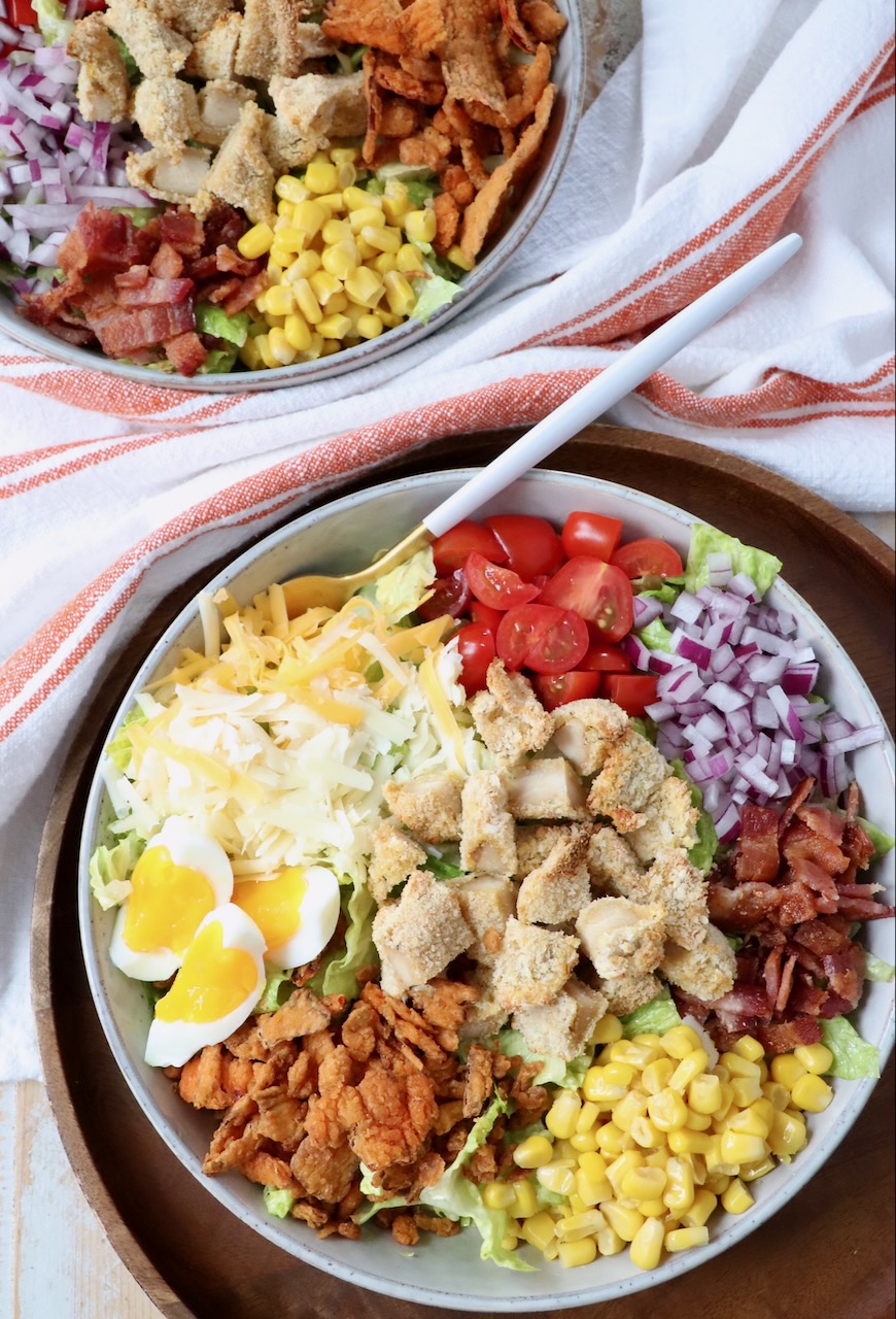 crispy chicken salad in two bowls with fork
