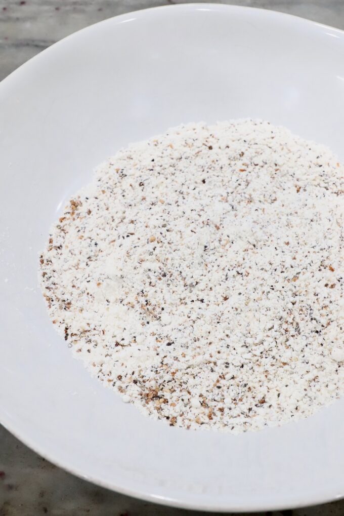 flour combined with lemon pepper seasoning in white bowl